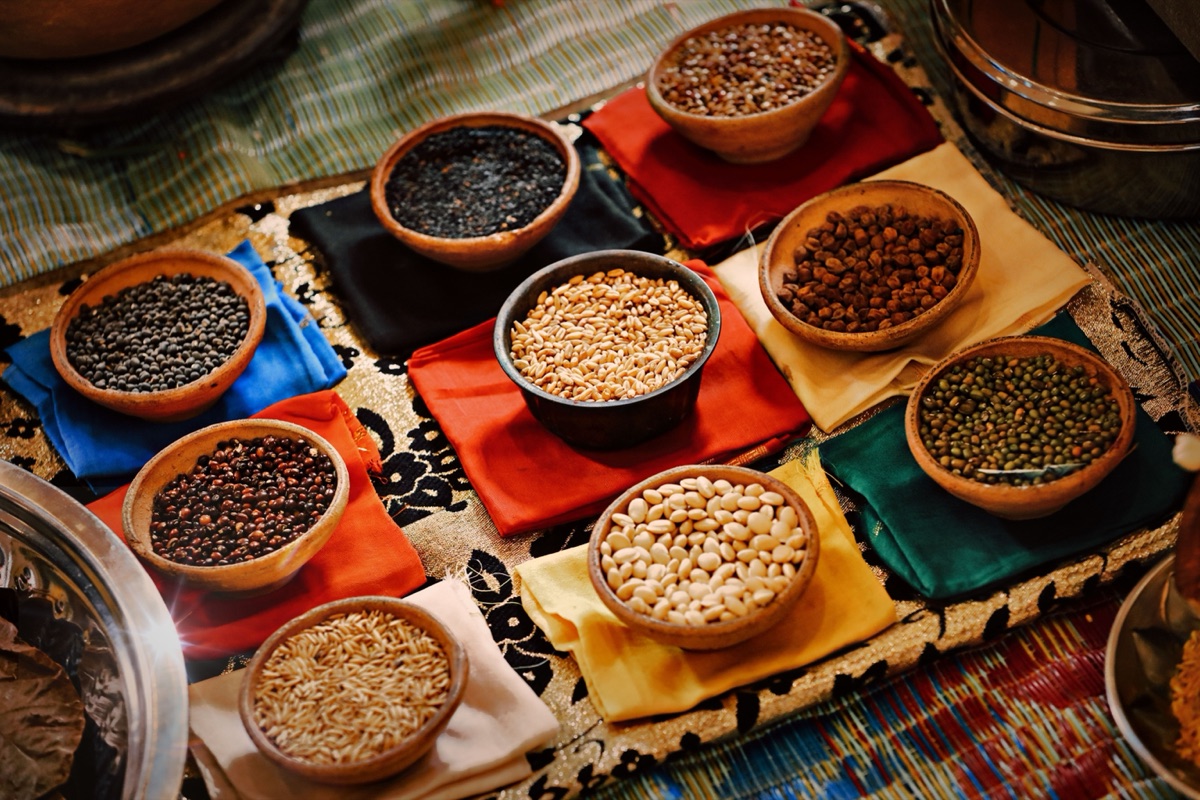 Clay bowls of dried lentils, beans and grains set on coloured cloths
