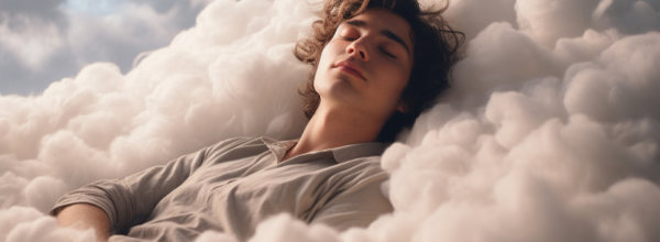 Young man with eyes closed lying back on soft white clouds